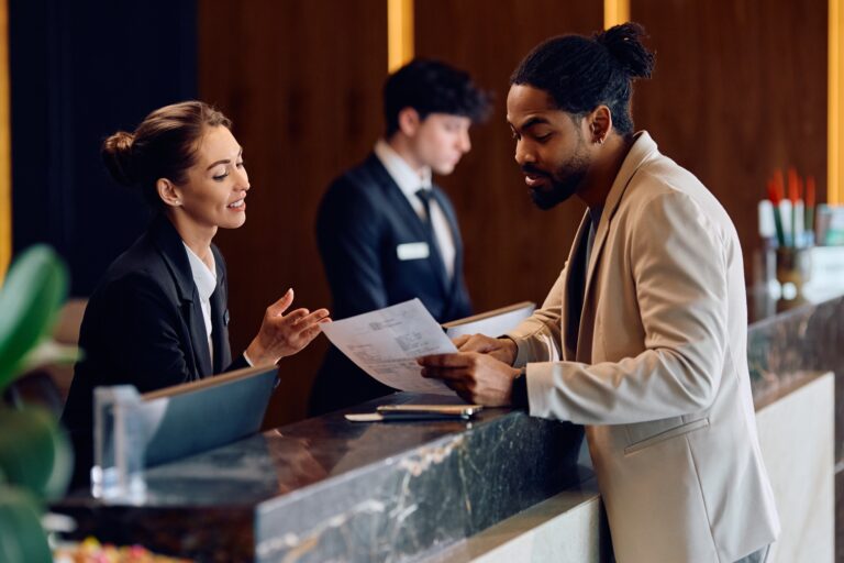 African American man checking in at reception desk in a hotel.